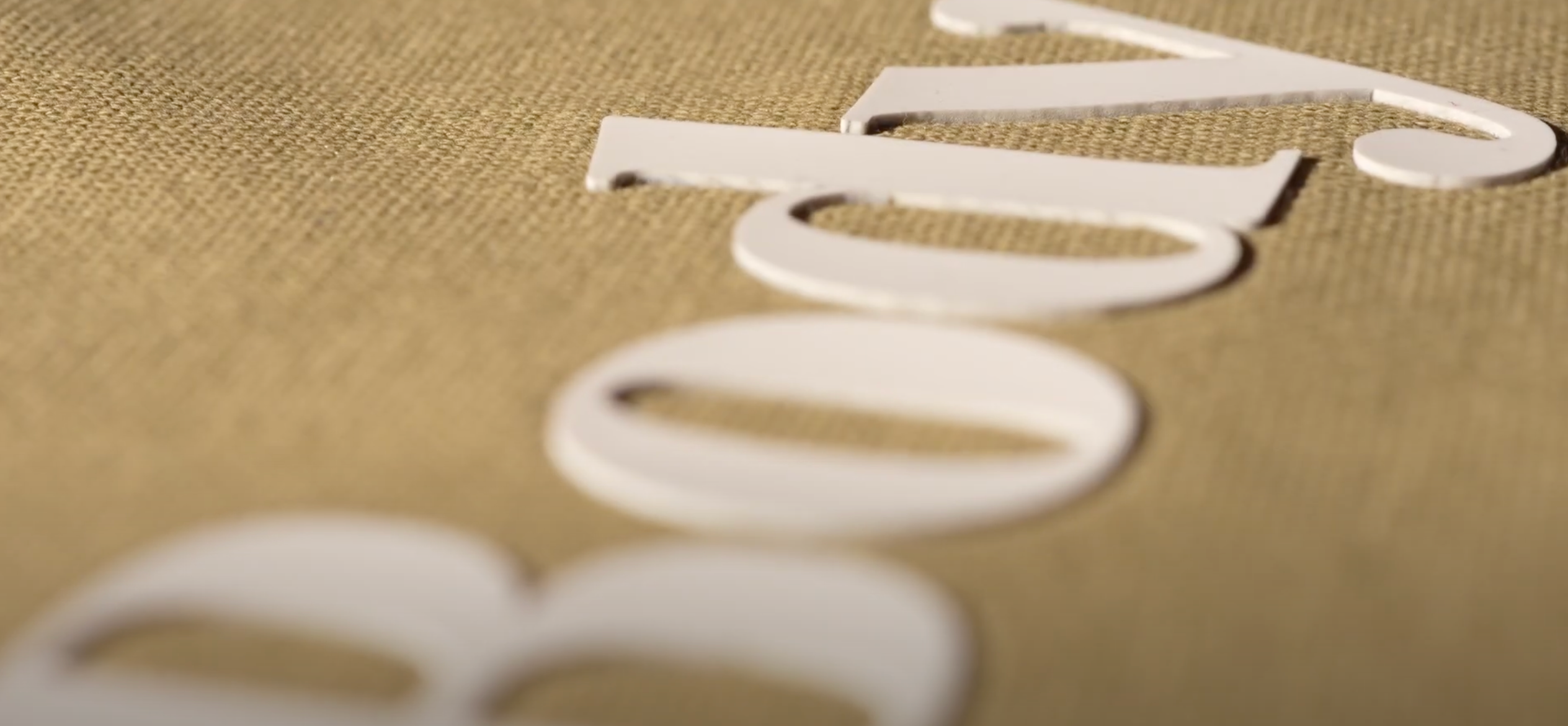White cut-out letters spelling 'body' on a textured beige background