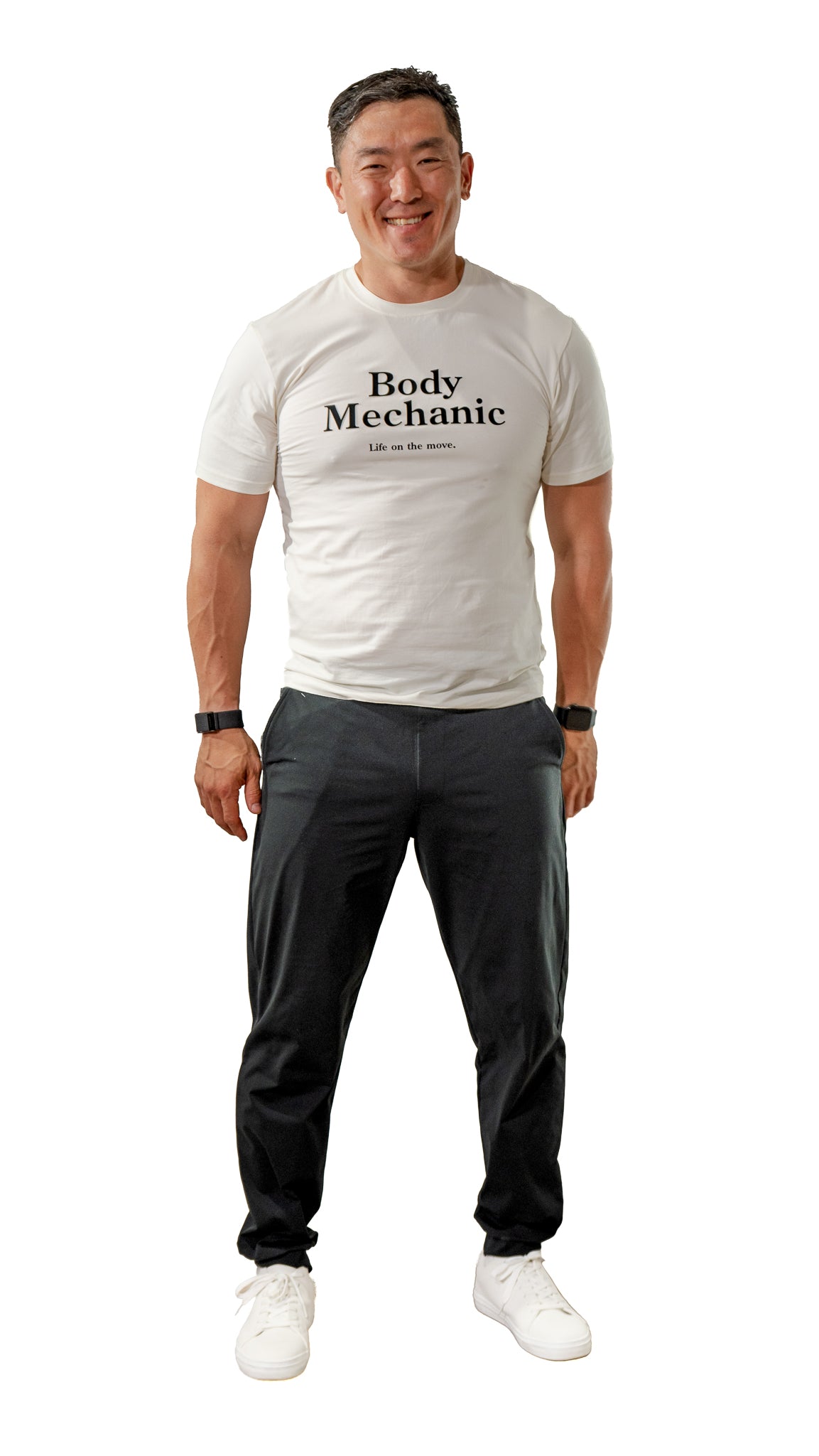 Man wearing a white t-shirt with 'Body Mechanic' text and dark pants on a white background