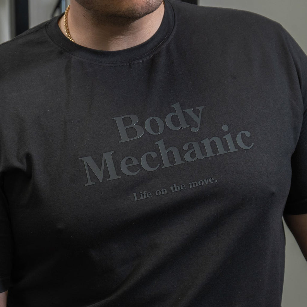 Person wearing a black t-shirt with 'Body Mechanic' text.